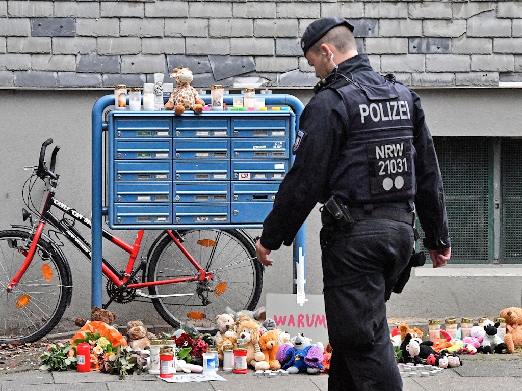Passanten haben nach den Morden Kerzen, Blumen und Kuscheltiere vor das Solinger Wohnhaus abgelegt.