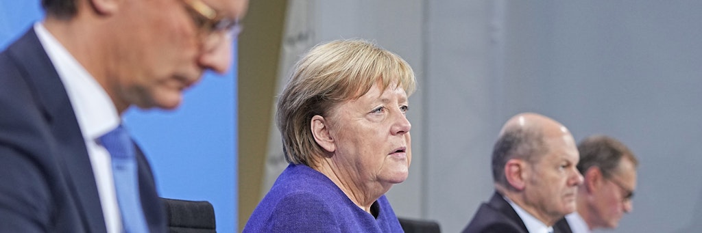 Hendrik Wüst (CDU), Ministerpräsident von Nordrhein-Westfalen, die geschäftsführende Bundeskanzlerin Angela Merkel (CDU), Olaf Scholz (SPD), geschäftsführender Bundesfinanzminister, und Michael Müller (SPD), Regierender Bürgermeister von Berlin, nehmen im Anschluss an die Videokonferenz der Bundeskanzlerin mit den Ministerpräsidenten an einer Pressekonferenz im Bundeskanzleramt teil. (v. l. n. r.)