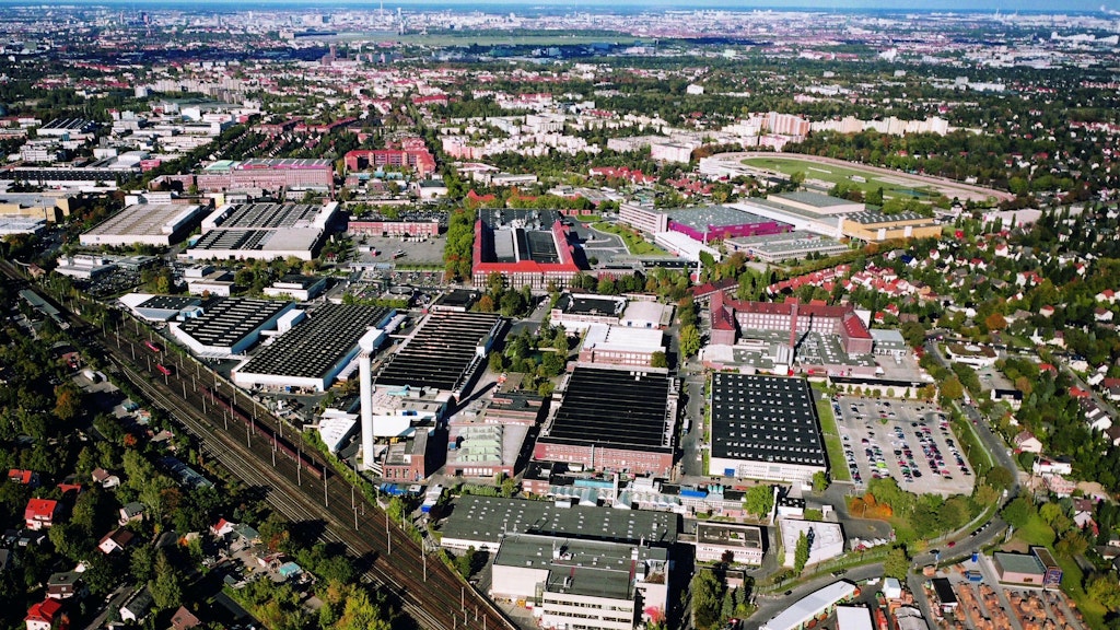 Das Mercedes-Werk an der Marienfelder Daimlerstraße von Süden gesehen. Im Hintergrund das Tempelhofer Feld, rechts davor die Trabrennbahn Mariendorf.