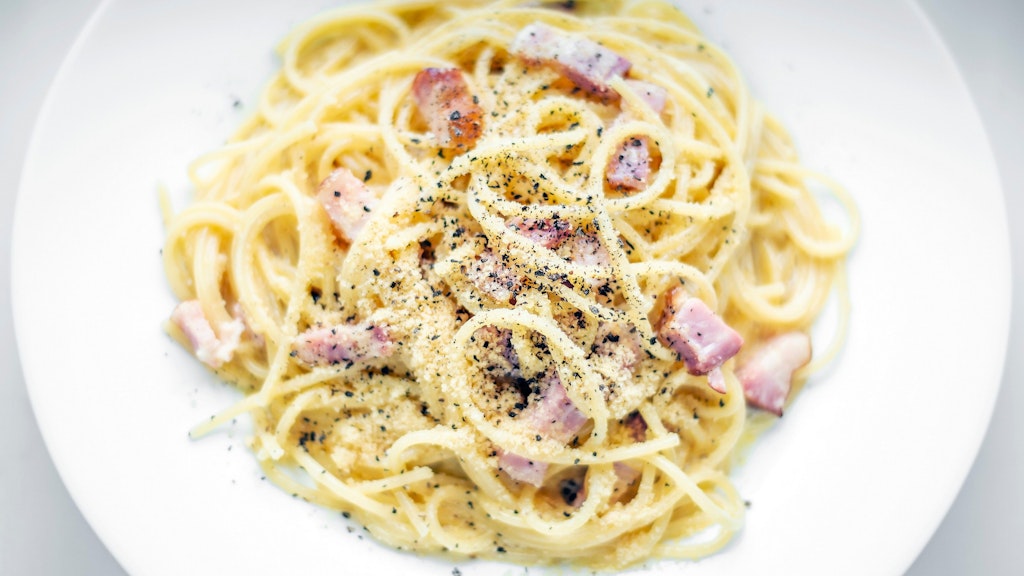 Geniales Rezept: Die Carbonara wird am Ende mit Pfeffer kräftig gewürzt und mit Parmesan bestreut. Lecker!