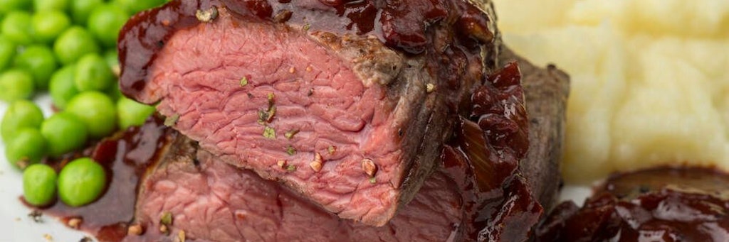 Feinstes Rindersteak mit Schmorzwiebeln und Kartoffel-Erbsen-Stampf ist wahrlich ein Genuss.