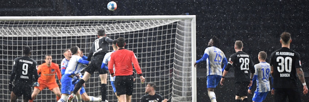 Augsburgs Michael Gregoritsch (M.) ssteigt am höchsten und trifft in der 97. Minute zum 1:1. Herthas Sieg war damit futsch.