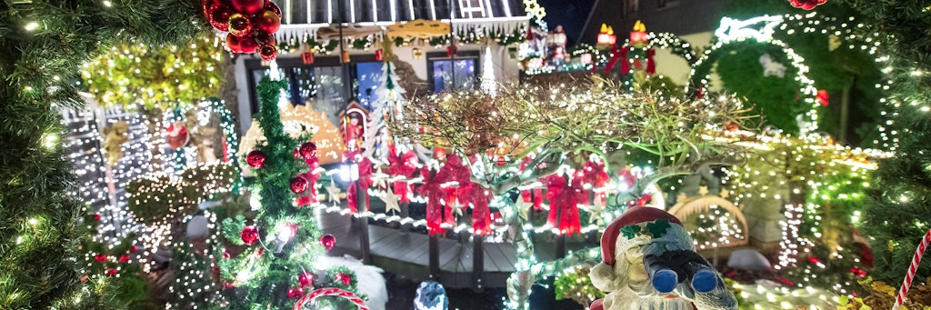 Ein weihnachtlich geschmücktes Haus erhellt die dunkle Nacht.