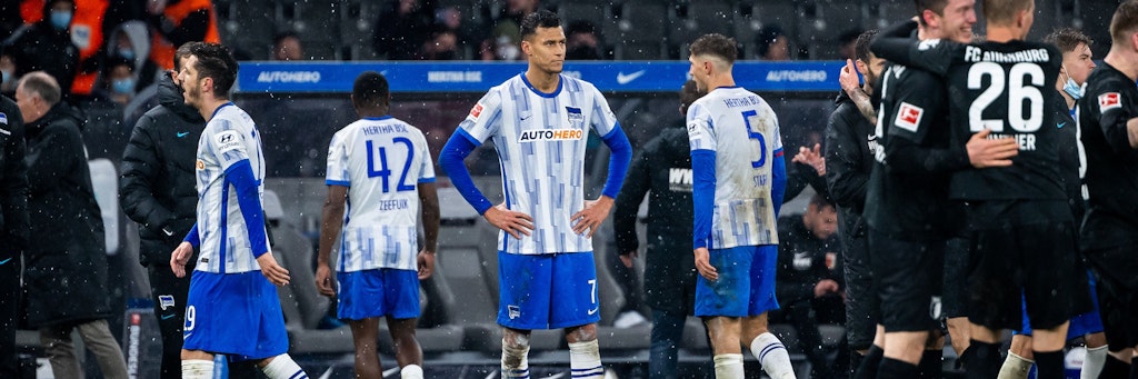 Fassungslos schaut Davie Selke nach dem Schlusspfiff auf die jubelnder Augsburger Spieler.