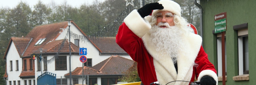 Der Weihnachtsmann fährt auf einem Elektro-Fahrrad der Deutschen Post zum Weihnachtspostamt.