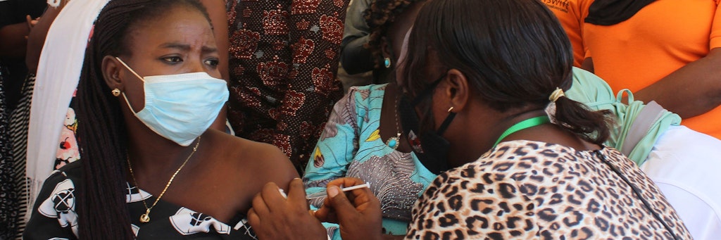 Nigeria, Abuja: Eine nigerianische Beamtin erhält eine Dosis des Corona-Impfstoffs von AstraZeneca, bevor sie ihr Büro betreten darf. Die Omikron-Variante des Coronavirus ist erstmals auch in Afrikas bevölkerungsreichstem Land Nigeria nachgewiesen worden. 