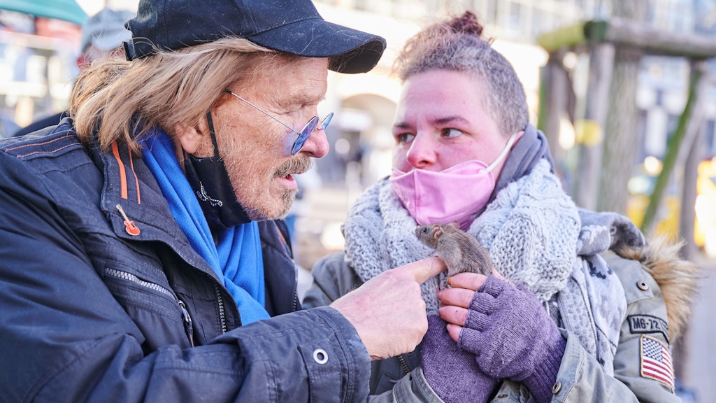 Frank Zander steht mit einer Obdachlosen Frau und ihrer Ratte vor dem Caritas-Foodtruck auf dem Alexanderplatz.