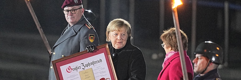 Bundeskanzlerin Angela Merkel (CDU) steht bei ihrer Verabschiedung durch die Bundeswehr zwischen dem Generalinspekteur der Bundeswehr, General Eberhard Zorn (l), und der Verteidigungsministerin Annegret Kramp-Karrenbauer (CDU). Mit einem Großen Zapfenstreich wurde Kanzlerin Merkel gegen Ende ihrer Regierungszeit nach 16 Jahren im Bendlerblock verabschiedet. 