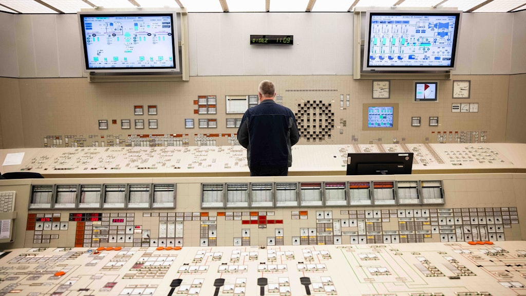 Ein Mitarbeiter steht an einem Kontroll- und Steuerungspult im Leitstand des Kernkraftwerk Brokdorf.