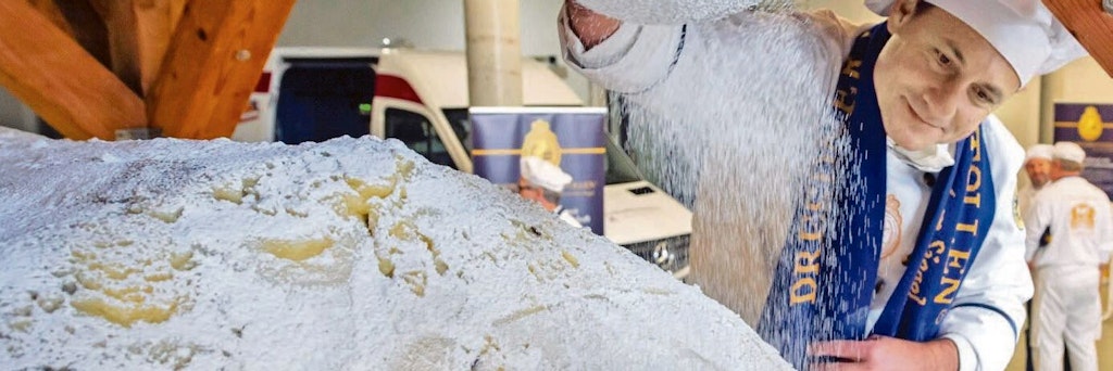 Vor zwei Jahren war die Welt noch in Ordnung auf dem Dresdner Striezelmarkt: Stollenbäcker Tino Gierig mit einem Riesen-Stollen im Dezember 2019.