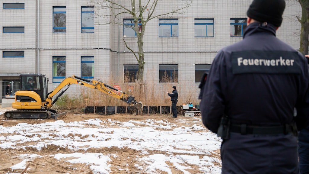 Ein Bagger entfernt am Sonntag die Erde, die nach der Entdeckung der Bombe sicherheitshalber wieder über sie gedeckt worden war.