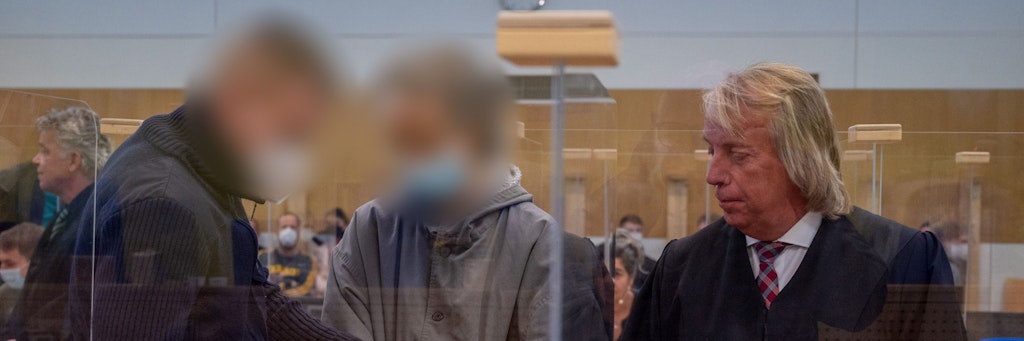 Dem Hauptangeklagten (Mi.) im sogenannten Cyberbunker-Prozess werden von einem Justizbeamten im Gerichtssaal die Handschellen abgenommen. Neben ihm steht sein Verteidiger Uwe Hegner.
