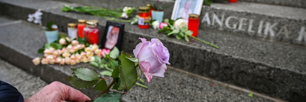 Ein Passant legt eine Rose auf den Treppenstufen zur Gedächtniskirche ab, in die die Namen der Opfer eingraviert sind.