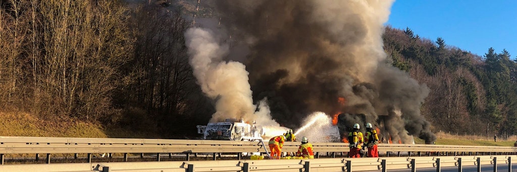 Feuerwehrleute kämpfen auf der A3 mit den Flammen. Ein Laster hat hier einen Militärkonvoi der US-Armee gerammt.