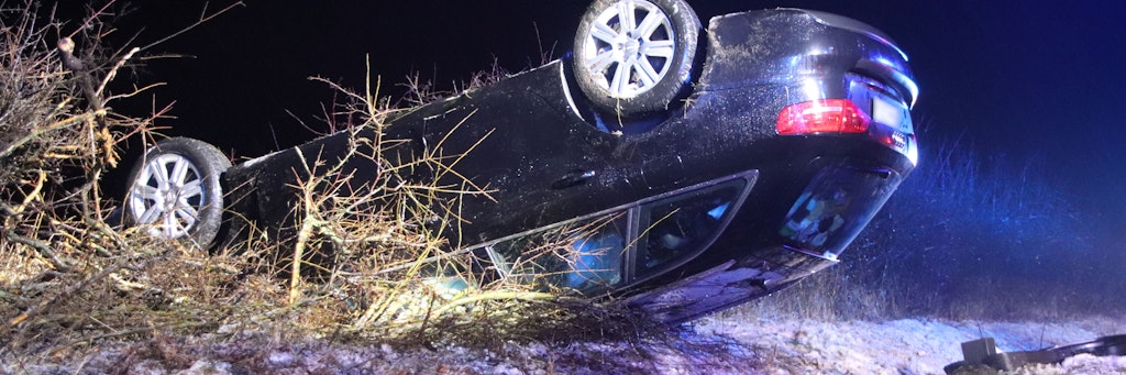in Pkw liegt nach einem Unfall auf schneebedeckter Straße auf der L50 zwischen Drachhausen und Turnow in einem Straßengraben auf dem Fahrzeugdach.