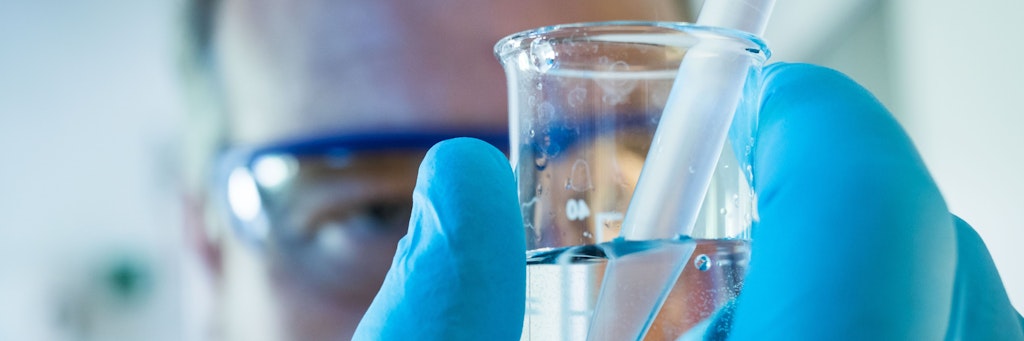 Eine Fachkraft für Abwassertechnik analysiert eine Probe des geklärten Wassers. 