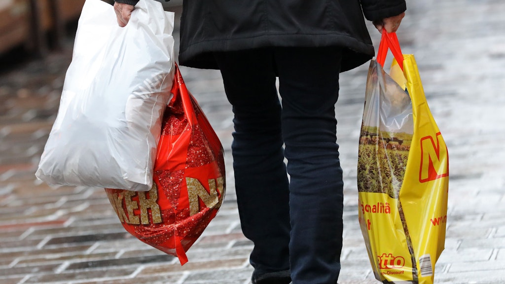 Eine Frau geht mit Einkaufstüten aus Plastik über den Fußweg. Leichte Plastiktüten dürfen in Deutschland ab 2022 nicht mehr ausgegeben werden. 