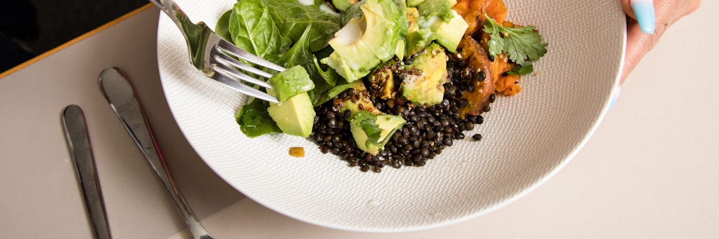 Eine Bowl mit Belugalinsen und Kichererbsen lässt sich mit Kürbis, Avocado, Spinat, Leinsamen und Sesam anrichten. 