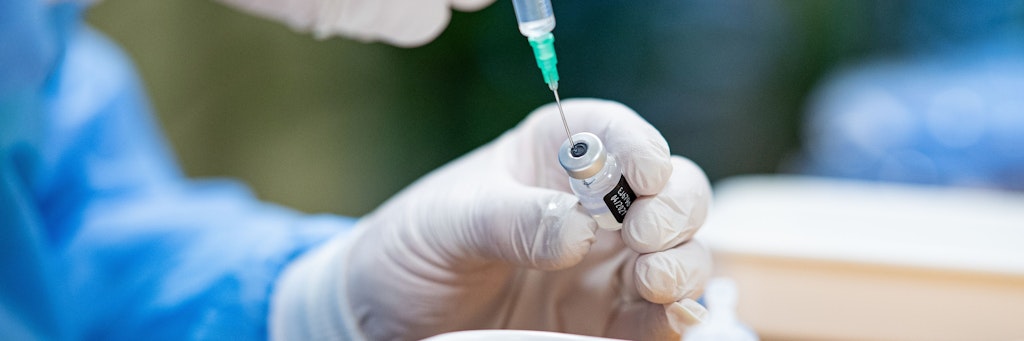 Ein Infektiologe zieht in einem Seniorenheim eine Spritze mit Impfstoff gegen das Coronavirus auf. 