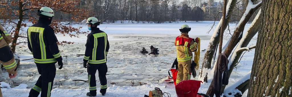 Rettungstaucher der Feuerwehr suchen nach der vermissten Person im Karpfenteich.