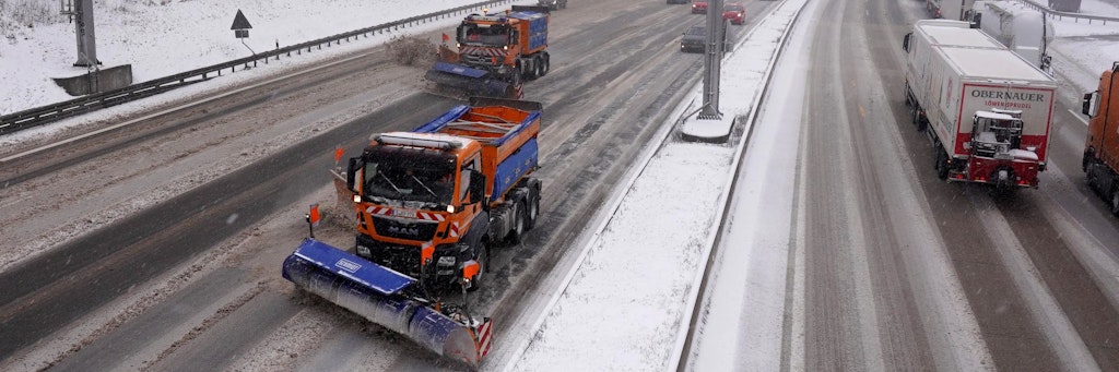 Zwei Räumfahrzeuges des Winterdienstes räumen Neuschnee auf der A8 weg.