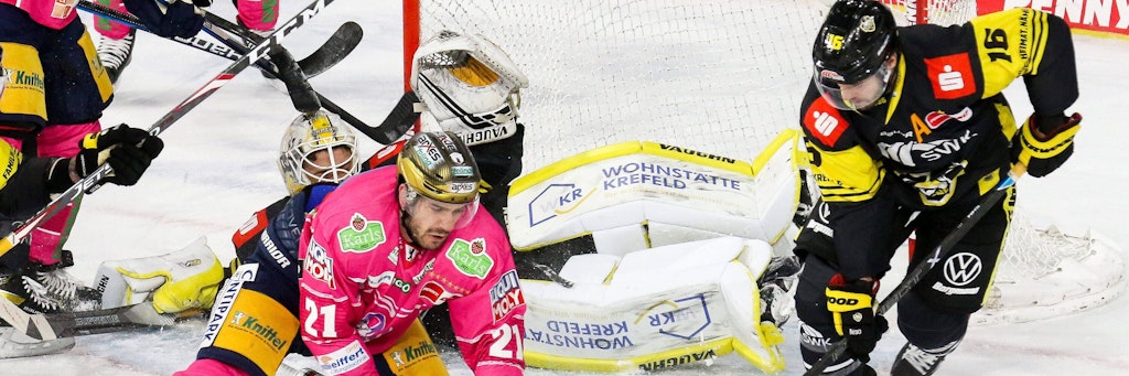 Eisbär Giovanni Fiore (Mitte) kommt vorm Krefelder Tor gegen Brett Olson(r.) nicht an den Puck ran. Dabei liegt Pinguin-Keeper Sergei Belov schon auf dem Rücken.