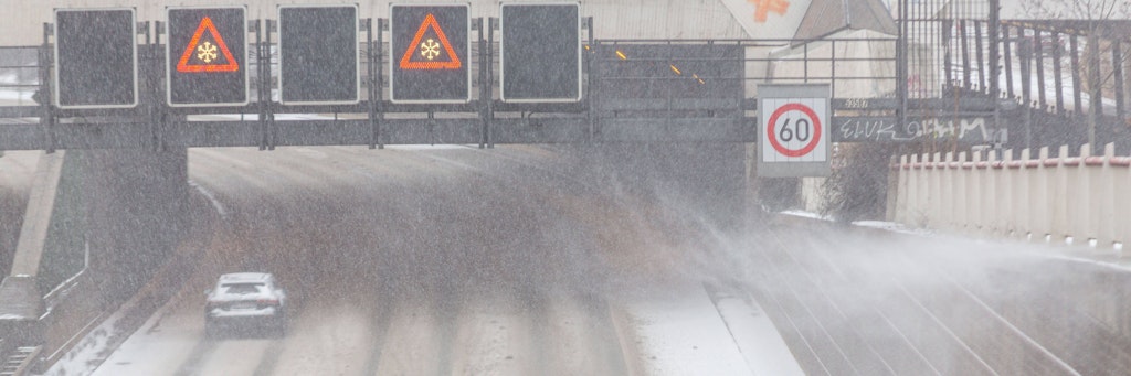 Schilder auf der Berliner A100 zeigen Glätte an.