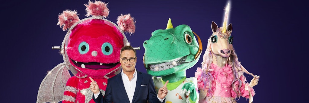 Moderator Matthias Opdenhövel mit Monstronaut (l.), Dinosaurier und Einhorn.