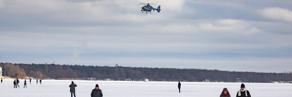 Sonntag am Berliner Müggelsee: Die Polizei fordert in Lautsprecherdurchsagen Menschen auf, die Eisfläche zu verlassen.