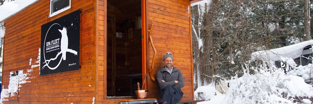 Henning Grentz sitzt vor seiner selbst gebauten Miet-Sauna im Schnee.