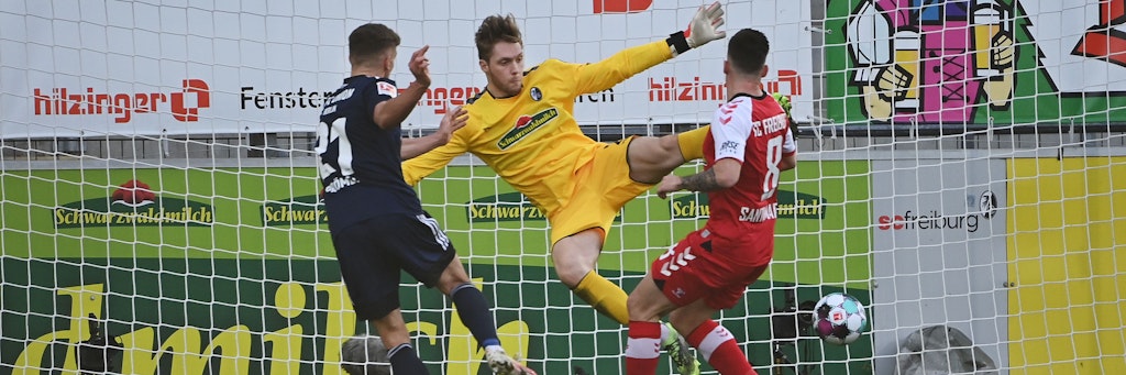 Grischa Prömel (l.) macht das Tor zum 1:0. Freiburgs Torwart Florian Müller (M,) kann den Ball nicht parieren.