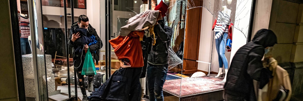 Demonstranten räumen Klamotten aus einem Modegeschäft in Barcelona.