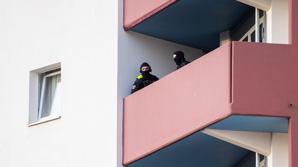 Vermummte Polizisten sichern den Balkon eines Verdächtigen im Märkischen Viertel.