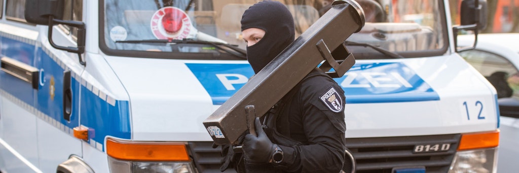 Ein Beamter eines mobilen Einsatzkommandos (MEK) trägt eine Ramme zu einer Islamisten-Wohnung. 
