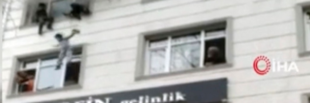 Das Videostandbild zeigt die spektakuläre Szene: Die Mutter wirft ihre Kinder aus dem dritten Stock des brennenden Hauses.