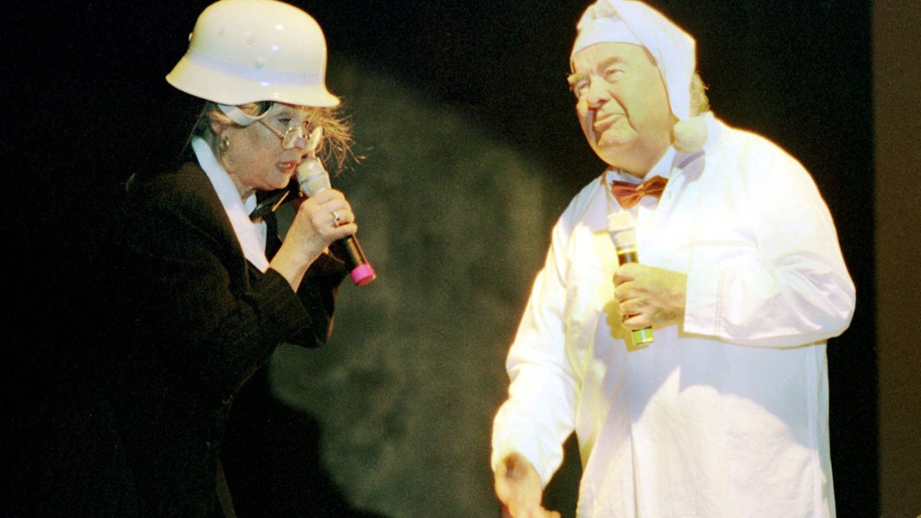 Heinz Quermann im Nachthemd und Schauspielerin Helga Piur mit Feuerwehrhelm spielen einen Sketch in der Show „Zwischen Frühstück und Gänsebraten“ 1998.