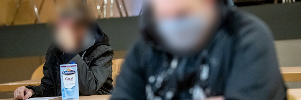 Zwei der Angeklagten sitzen vor Prozessbeginn in der Stadthalle Verden. Gemeinsam mit einer weiteren Angeklagten sollen sie eine 19-Jährige gefesselt und mit einer Betonplatte lebend in der Weser versenkt haben.