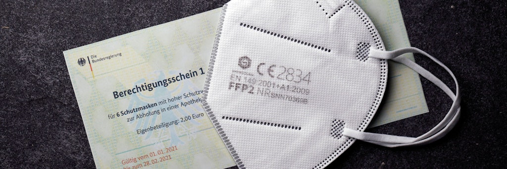 Eine FFP2-Maske auf einem Berechtigungsschein der Bundesregierung.