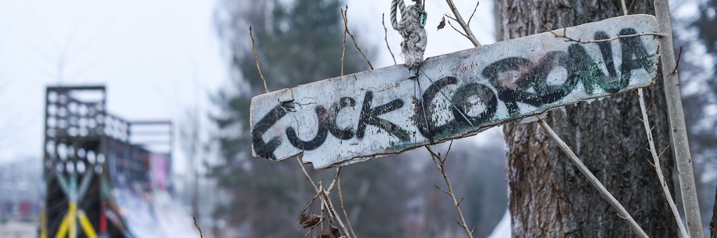 An einem Baum im Mellowpark hängt ein Schild mit der Aufschrift „Fuck Corona“. 
