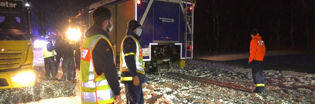 Mitarbeiter des Technischen Hilfswerks (THW) stehen während eines Staus auf der A2 bei Bielefeld. Fahrer verbrachten hier zum Teil die ganze Nacht auf der Straße und mussten bei klirrender Kälte in ihren Autos ausharren. 