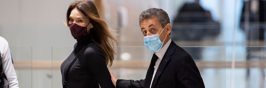 Nicolas Sarkozy hat die Hand auf dem Arm seiner Frau Carla Bruni-Sarkozy, als er ins Gericht geht. 