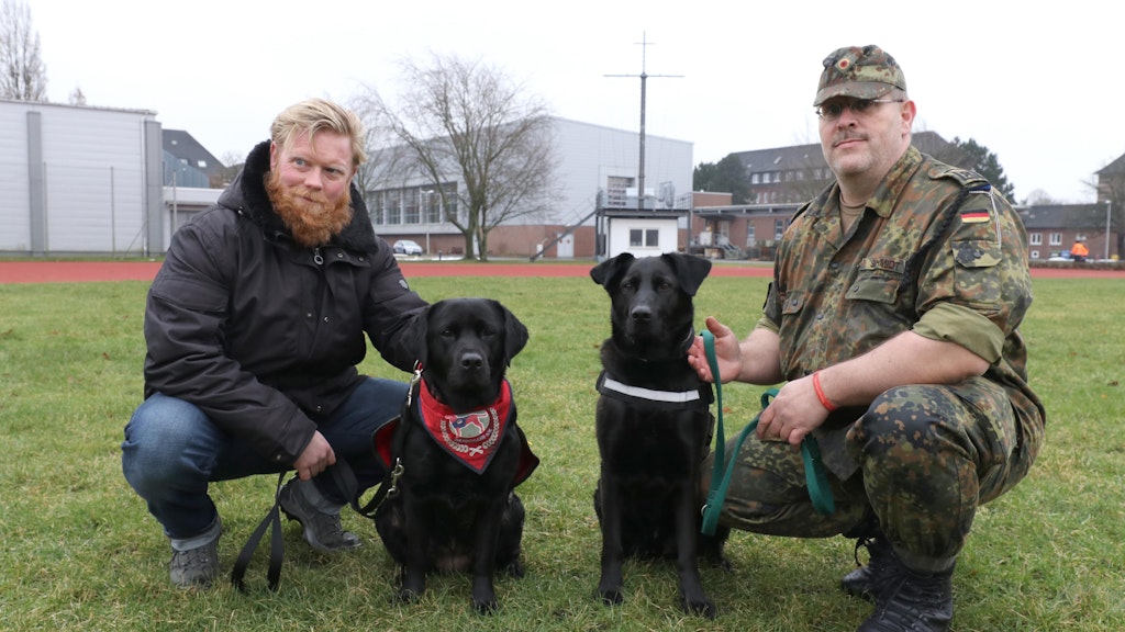 Kapitänleutnant Frederik Hesse (l.) sitzt neben seinem Hund Dorle, Hauptfeldwebel Alexander Schmidthat Krümel an seiner Seite. 