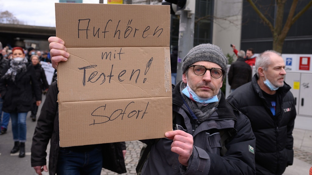 Ein Demonstrant fordert während der Kundgebung, alle Corona-Tests zu stoppen.