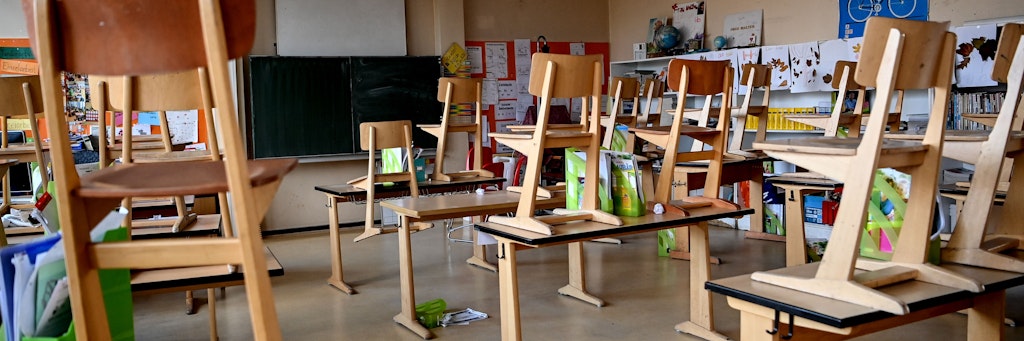 In einer Berliner Grundschule stehen die Stühle auf den Tischen. Niemand ist in der Klasse.