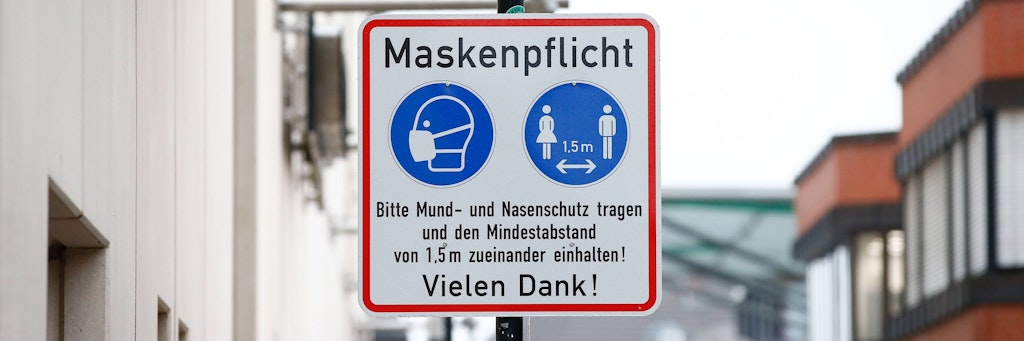 Ein Schild weist auf die bestehende Maskenpflicht in der Fußgängerzone hin. (Symbolbild)