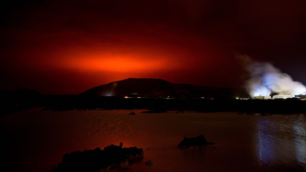 Der Himmel über dem Vulkan leuchtet rot.