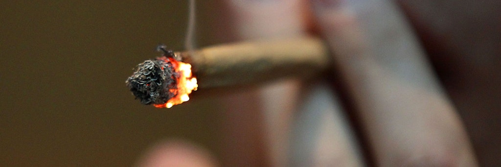 Ein Mann raucht einen Joint mit Marihuana. 