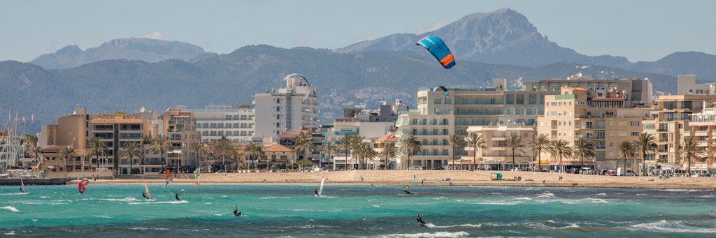 Kitesurfer genießen einen Tag im Meer vor der Skyline von Can Pastilla. 