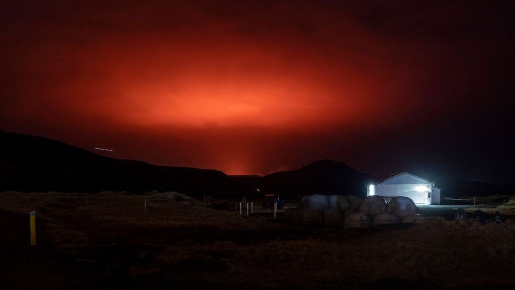Rot erleuchteter Himmel nach einem Vulkanausbruch am Berg Fagradalsfjall.
