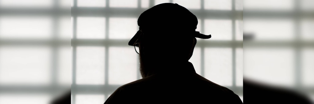 Im Alter von 84 Jahren steht Deutschlands ältester Häftling in der Justizvollzugsanstalt vor dem vergitterten Fenster eines Besucherraums.